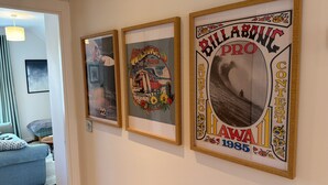 Seinällä on kolme kehystettyä julistetta, joissa on kuvia surffauksesta ja tekstiä.