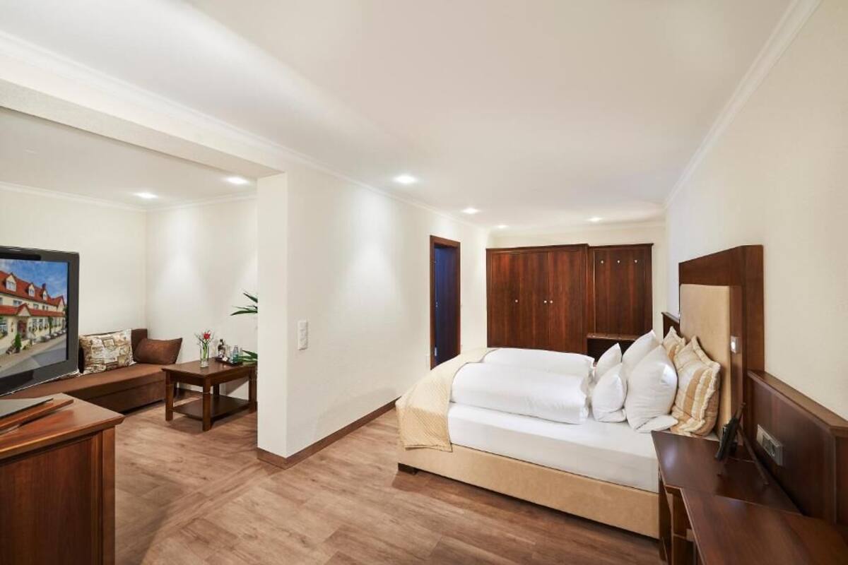 Un dormitorio con una cama, muebles de madera, un televisor y un cuadro.