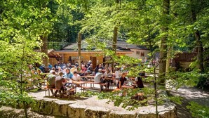Un espacio al aire libre para reuniones con asientos de piedra y un edificio al fondo.