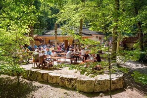 An outdoor gathering area with stone seating and a building in the background.