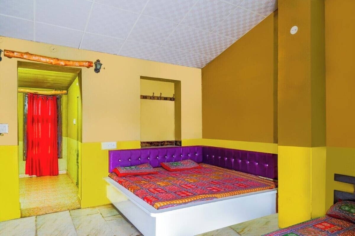 Een kamer met een bed, een deur en een spiegel aan de muur.