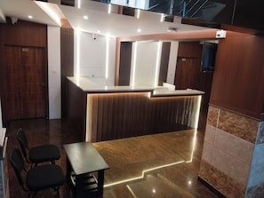 A reception area with a counter, seating, and a staircase.