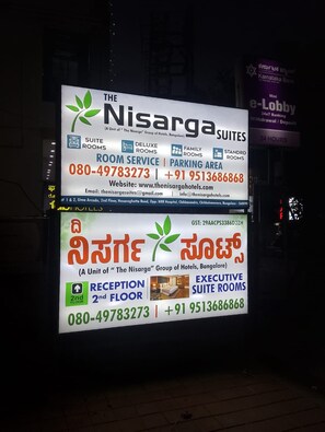 A hotel signboard with contact information, room service, and suite options.