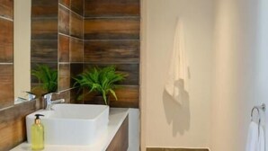 A modern bathroom with a large mirror, two sinks, and a shower area. - The Royal Bryanston (Sandton)