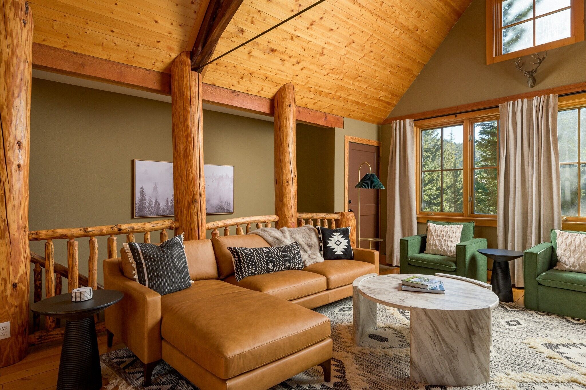 A cozy living room with a leather sofa, a round coffee table, and a green armchair.