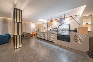 Una moderna zona de recepción con mostrador, asientos y una pared decorativa.