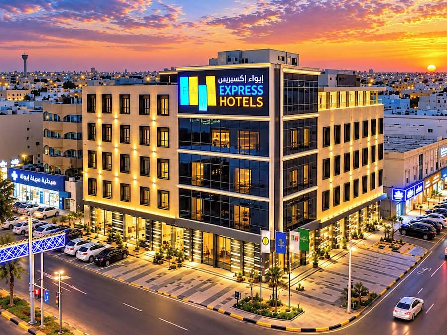 A multi-story hotel with a prominent sign for 'Express Hotels' and a parking lot with several cars.