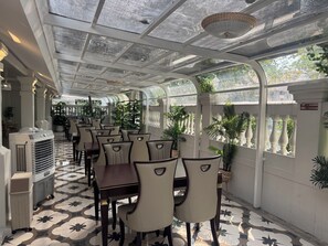 A restaurant with a glass ceiling, white columns, and patterned floor tiles. - Best House Luang Prabang (Luang Prabang)