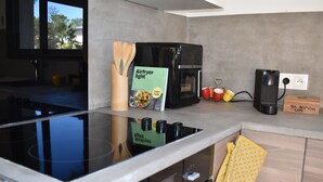 Une cuisine moderne avec un fourneau noir, une machine à café et une boîte à infuseur à thé.