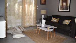 Un salon avec un canapé, une table basse, une lampe et un tableau au mur.