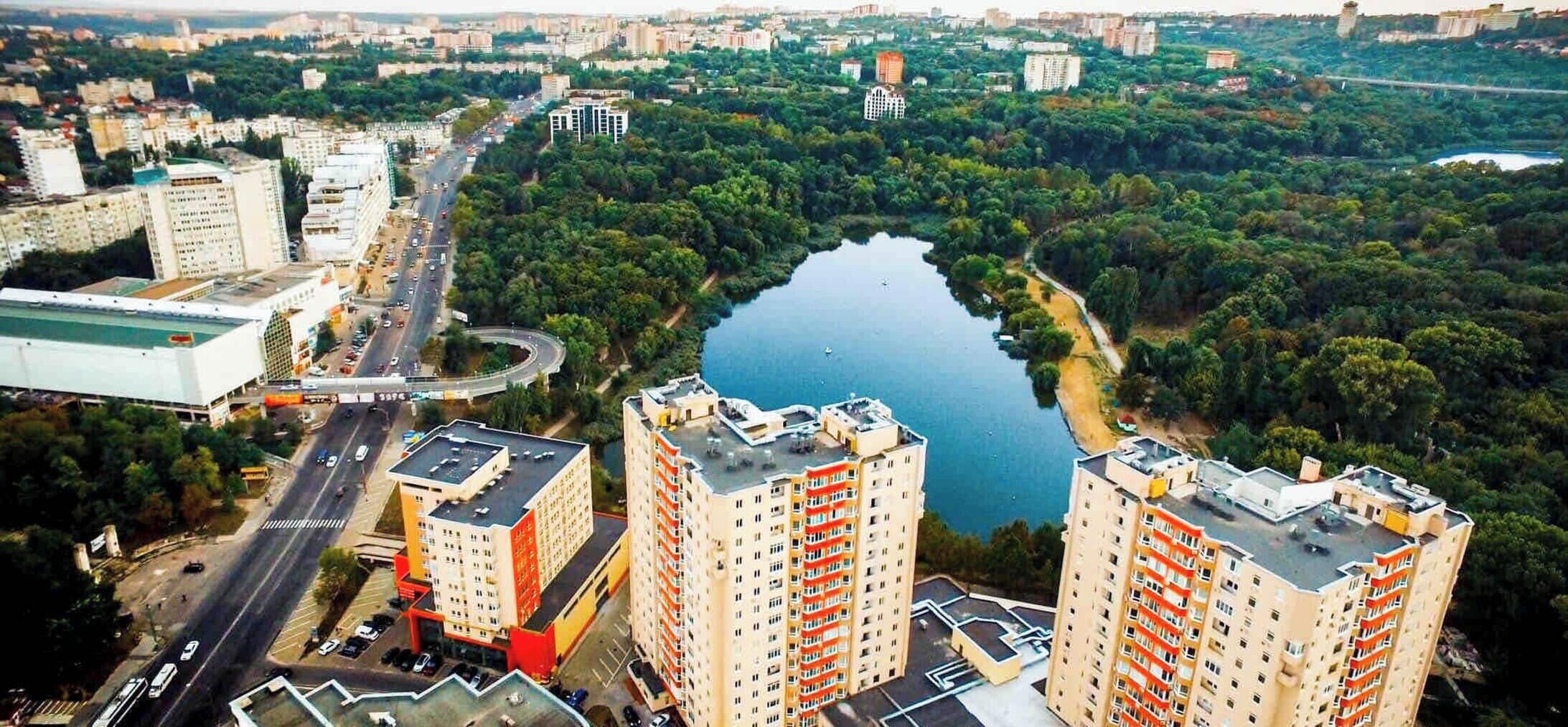 Ein Hochhaus mit mehreren Stockwerken, einem zentralen Innenhof und einer umliegenden Stadt mit Straßen und Grünflächen.