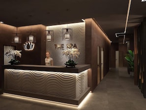 Un comptoir d’accueil au design moderne, orné d’un motif ondulé et d’une enseigne indiquant « THE SPA ».