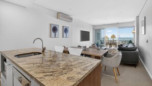Una cocina moderna con encimera de granito, pileta integrada y un comedor con mesa y sillas.