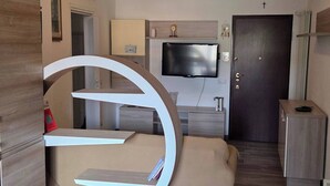 A modern bedroom with a bed, a TV, and a desk. - Charming Central Apartment Near Lake Maggiore in Arona (Arona)