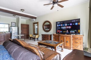 A living room with a sofa, coffee table, TV, and a ceiling fan. - 8203 - King, Ocean Dream, Cabarete! (Cabarete)