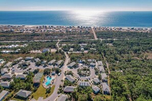 An aerial view of a residential area with houses, a swimming pool, and a beach in the background. - 2602 Rookery 1 2 A Shiny Penny - beach hot tub pool (Gulf Shores)