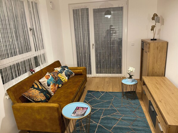 Ein Wohnzimmer mit einer Couch, einem Couchtisch, einem Schrank und einem gemusterten Teppich.
