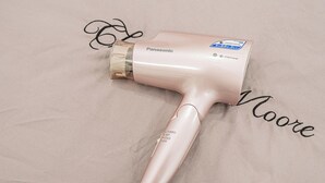 Een Panasonic haardroger met een bedieningspaneel op een stoffen oppervlak.