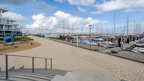 A marina with boats docked, a playground, and a building with a ramp.