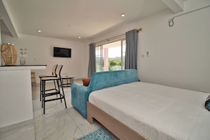 Un dormitorio con una cama, un escritorio y una silla.