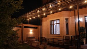 A building with a covered outdoor area, a piano, and a staircase. - Karaman Hotel (Tashkent)