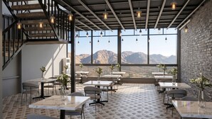 A modern dining area with tables, chairs, and hanging light fixtures. - Eco Boutique Satva Udaipur - Vegetarian with all Options (Udaipur)