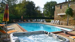 A swimming pool with lounge chairs and a hot tub. - Casale Le Rondini with a swimming pool and private garden (LUCIGNANO)