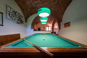 A pool table with a cue stick, a green pool table, and a brick ceiling. - Casale Le Rondini with a swimming pool and private garden (LUCIGNANO)