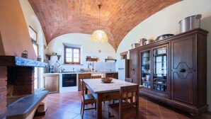 A kitchen with a brick ceiling, a marble countertop, and wooden cabinets. - Casale Le Rondini with a swimming pool and private garden (LUCIGNANO)