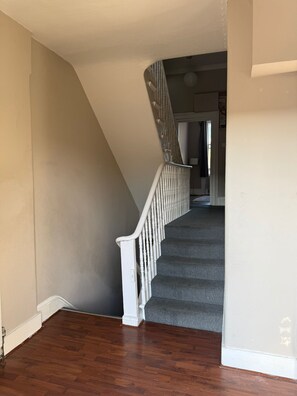 Eine Treppe mit weißer Handlauf, die zu einer Empore führt.