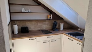 Una cucina con piano di lavoro in legno, forno integrato, macchina per il caffè e lavandino.