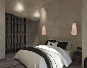A modern bedroom with a large bed, pendant lights, and a textured wall. - Anemos Central Fira (Santorini)