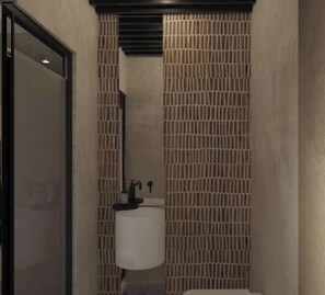 Ein Badezimmer mit Toilette, Waschbecken und einer Sichtschutzwand.
