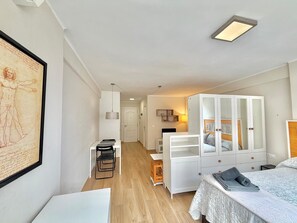 Quarto moderno com cama, escrivaninha e guarda-roupa.