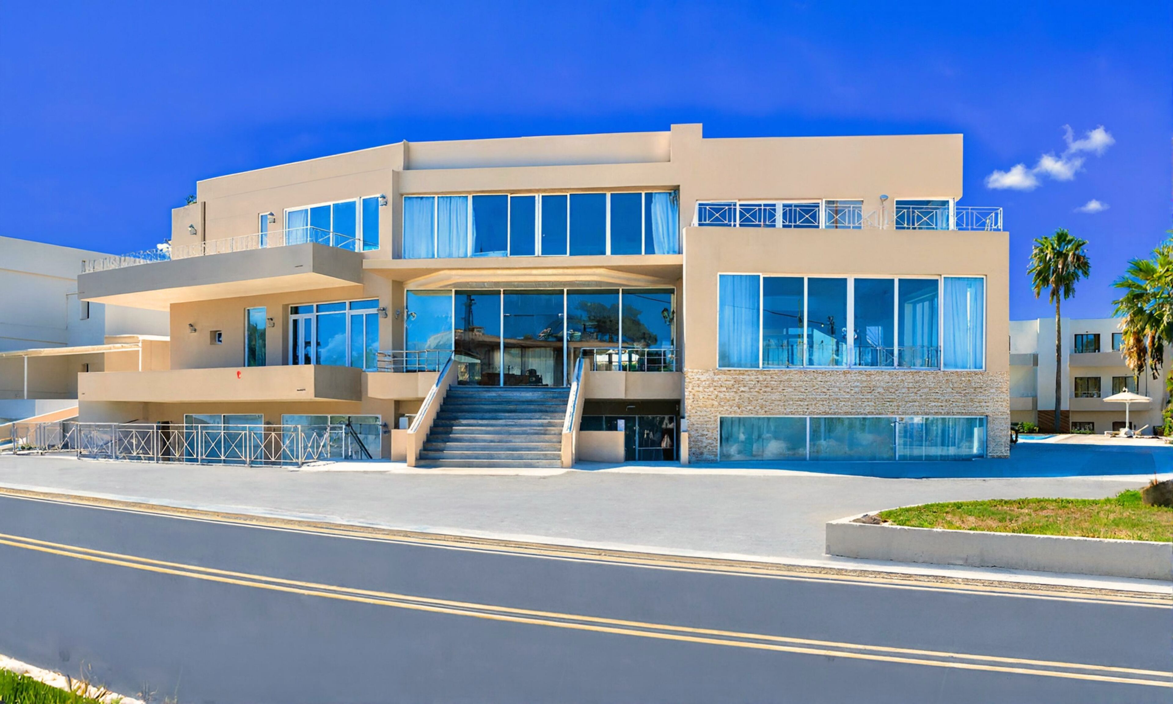 A modern multi-story hotel with a central staircase, large windows, and a swimming pool.