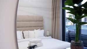 Hotelkamer met een groot bed, een bedlampje, een potplant en uitzicht buiten.