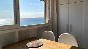 A room with a view of the sea, a wooden table, two chairs, and a white wardrobe. - Splendid apartment with sea view 50m from the beach with snack restaurant (Empuriabrava)