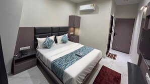 Ein modernes Schlafzimmer mit einem Bett, Nachttischen, einem Deckenventilator, einer Klimaanlage und einer Tür.