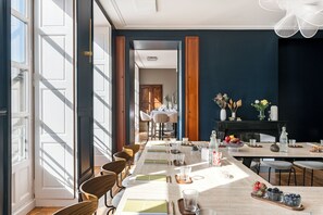 Un espace repas avec une longue table, des chaises et une vue sur une autre pièce.