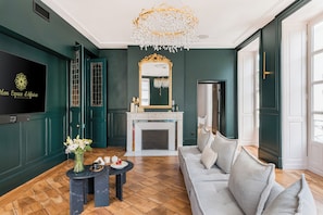 A modern living room with a fireplace, a sofa, a coffee table, and a decorative mirror. - Set of 4 apartments l 240m2 l Sleeps 14 l Ideal for receptions (Grenoble)