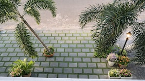 Un espacio al aire libre pavimentado con plantas en macetas y un farol.