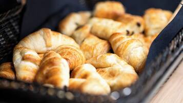 A basket filled with golden-brown croissants.