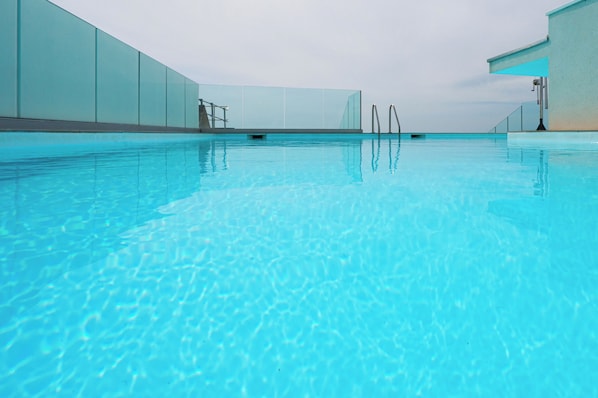 Ein heller, überdachter Pool mit Glaswänden und modernem Design.