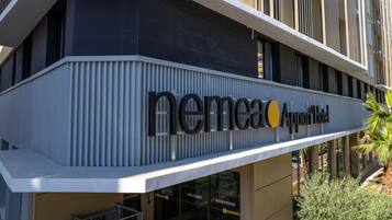 Señal de hotel con el nombre 'NEMEAO' e 'Appartments', indicando el tipo de alojamiento.