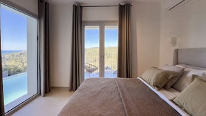 Un dormitorio con una cama grande, vistas a un balcón y un paisaje urbano.