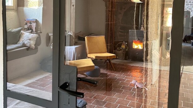 Une pièce chaleureuse avec une cheminée, un canapé et un fauteuil.