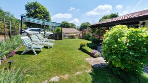 A well-maintained garden with a gazebo, outdoor seating, and a car parked nearby. - ‘Baita Piero e Afra’ Apartment with Mountain View, Balcony and Wi-Fi (Treviso Bresciano)