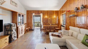 A wooden interior with a dining area, sofa, and a TV. - ‘Baita Piero e Afra’ Apartment with Mountain View, Balcony and Wi-Fi (Treviso Bresciano)