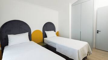 Ein Hotelzimmer mit zwei Einzelbetten, einem Kleiderschrank und einer Tür.