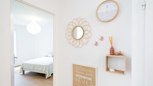 Un dormitorio con una cama, un reloj de pared, un espejo y una cita motivacional.